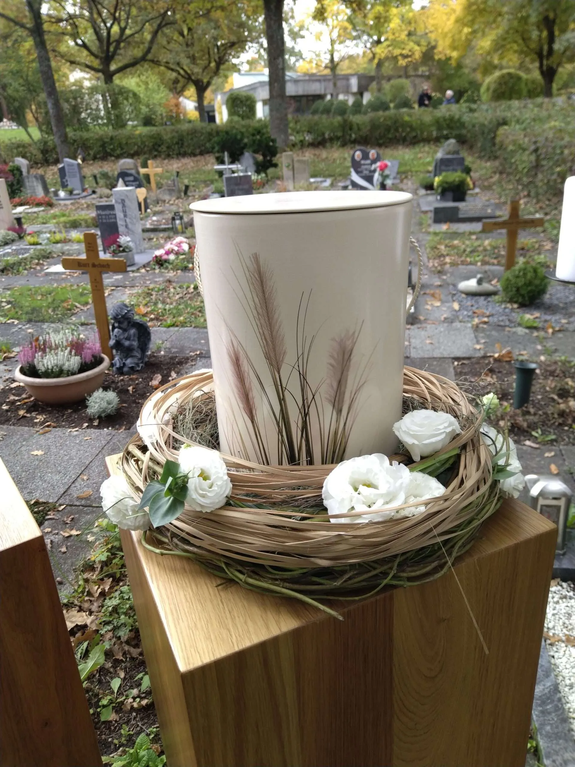 Urne mit Blumenschmuck vor der Beisetzung